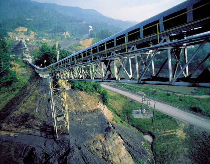 Long elevated conveyor belt structure crossing a valley with hills and forest in background, greens and grays, calm mood